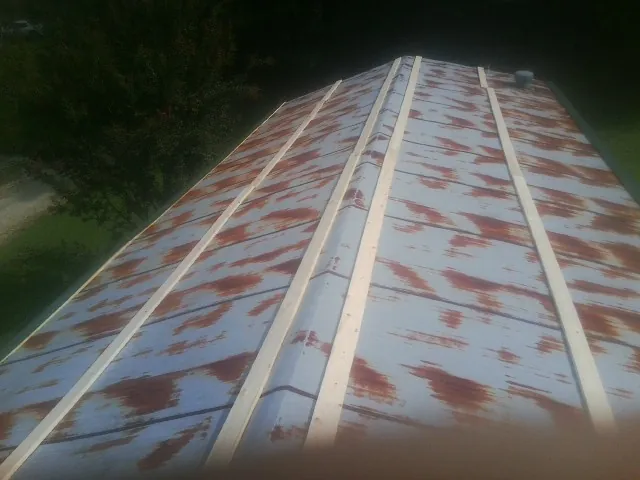 Rusted metal roof panels with new wood purlins before replacement — Storm Damage Roof Repair in Coinjock by Roofing Brothers