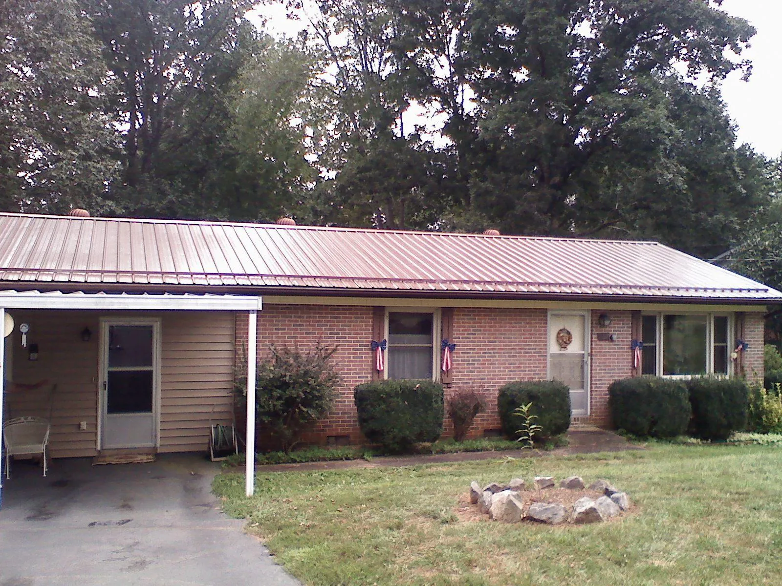 Bronze metal roof and carport on a brick ranch home — Roof Repair work by our crew in Coinjock